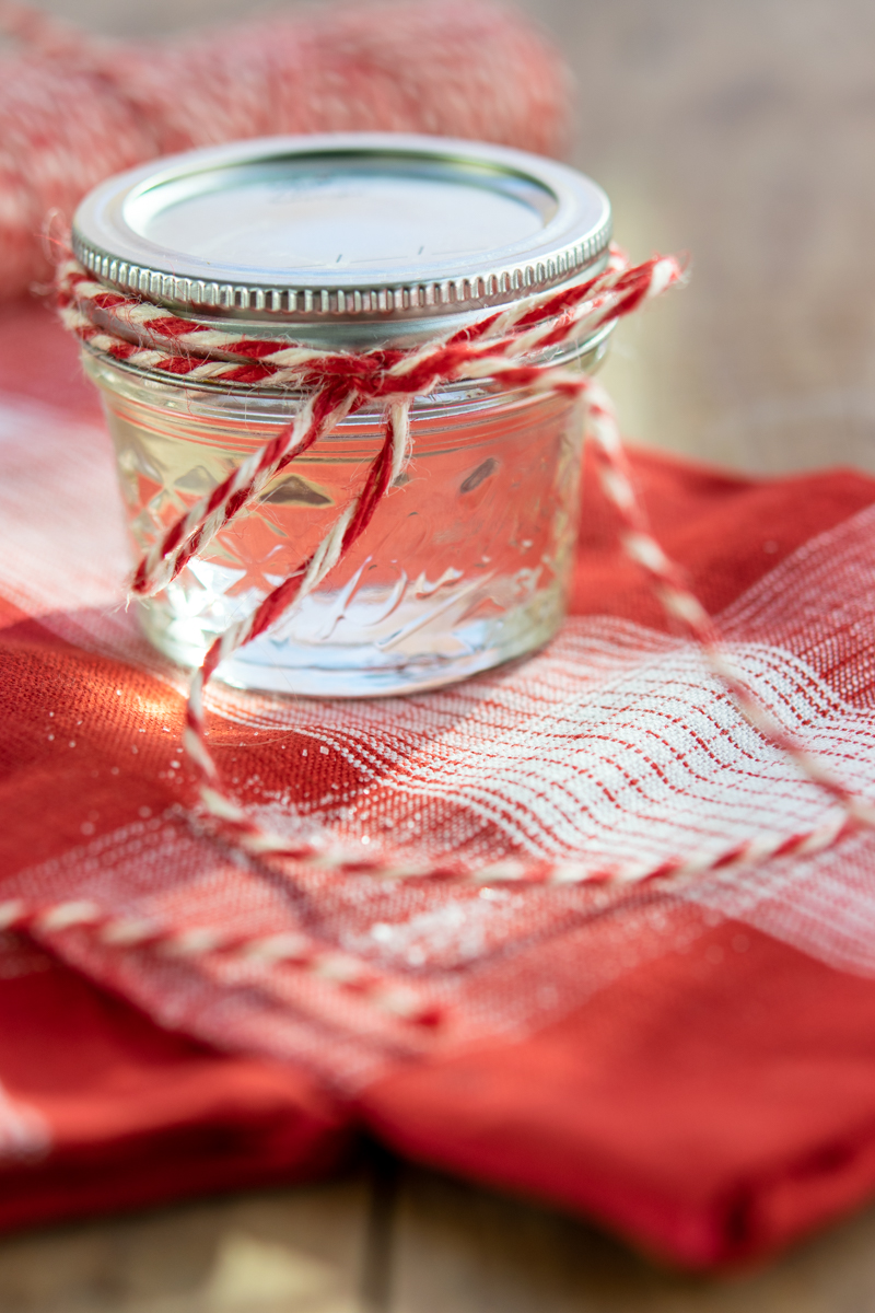 homemade peppermint syrup in a mason jar with red and white bakers string