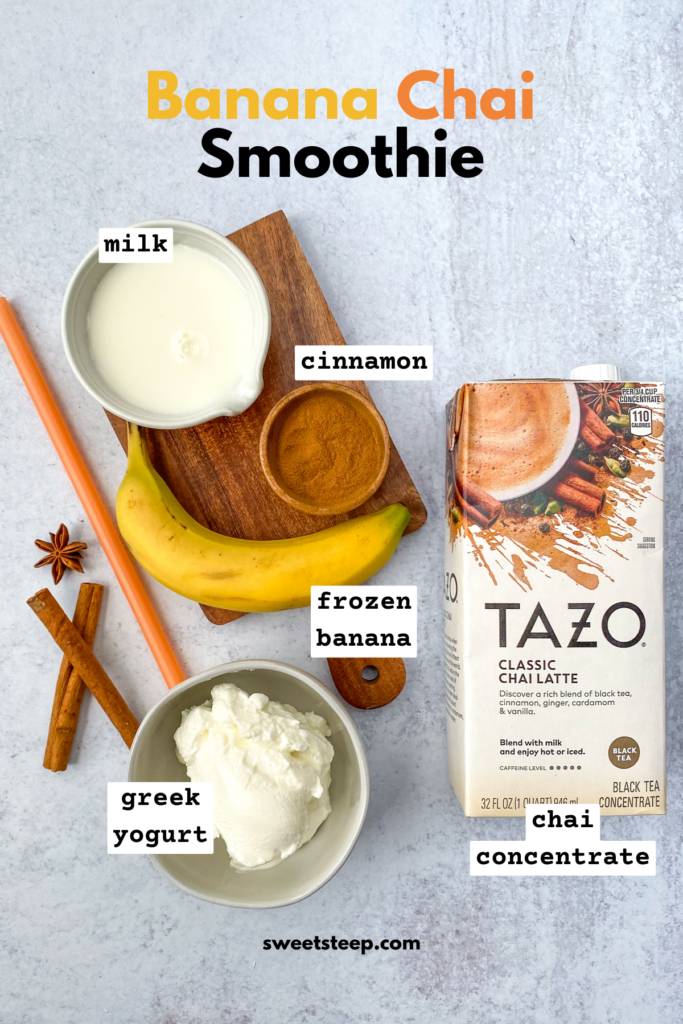 Overhead picture showing ingredients needed to make a banana chai smoothie, including pitcher of milk, small bowl of cinnamon, bowl of Greek yogurt, frozen banana, and a carton of chai latte concentrate.