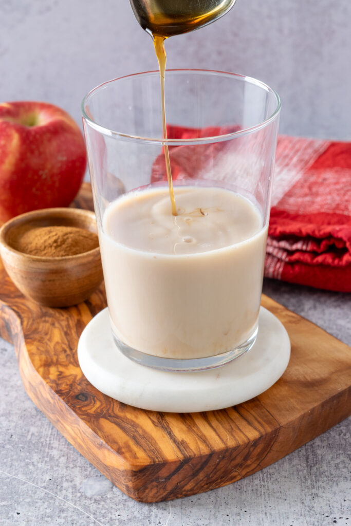 Apple brown sugar syrup being drizzled into homemade chai tea latte.