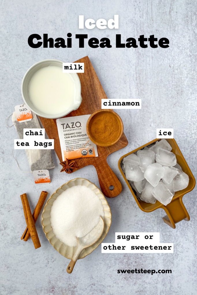 Overhead picture showing all the ingredients needed to make a homemade iced chai, including pitcher of milk, chai tea bags, sugar, cinnamon and ice cubes.