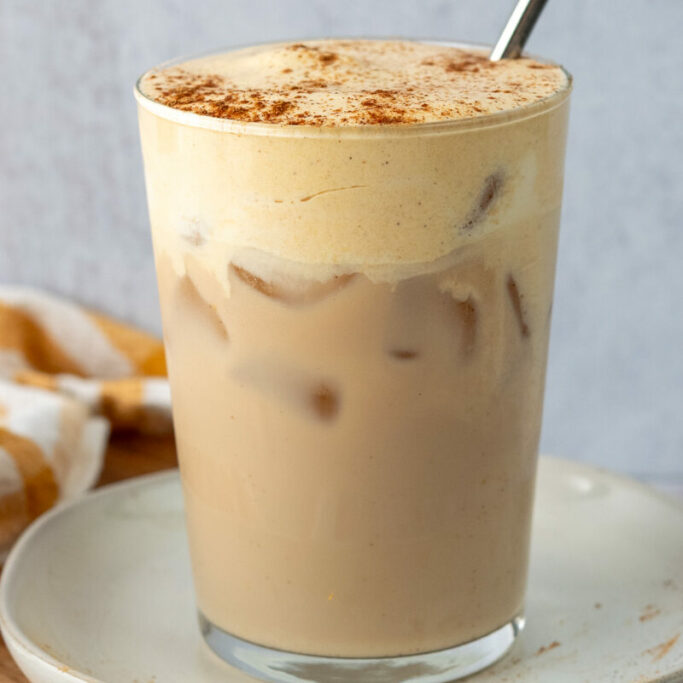 Navigation image for chai tea drink recipes, showing a glass of  chai iced tea topped with pumpkin cold foam.