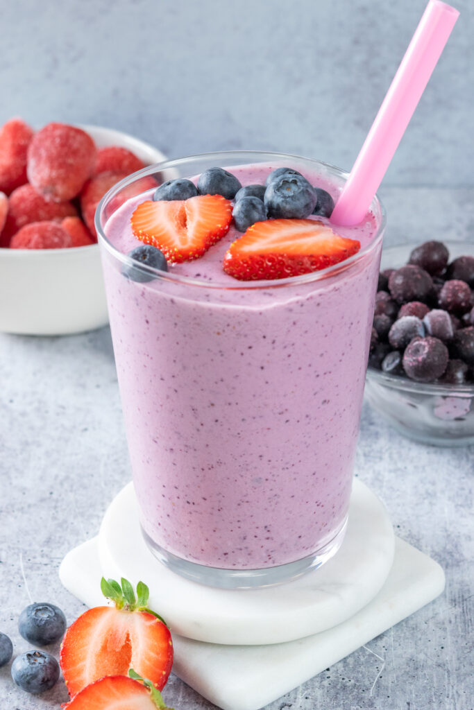 Homemade strawberry blueberry smoothie garnished with fresh blueberries and slices of strawberries.